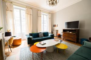 uma sala de estar com um sofá e uma mesa em Maison Manège Bordeaux Centre em Bordeaux