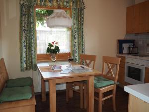 a kitchen with a wooden table and chairs and a window at Haus Mayerbüchler - Chiemgau Karte in Inzell