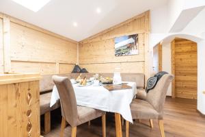 a dining room with a white table and chairs at Denggalahof in Münster