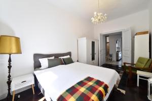 1 dormitorio con 1 cama blanca, mesa y sillas en 1BR in central Zagreb & main station, free parking, en Zagreb