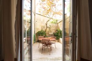 波爾多的住宿－Maison Manège Bordeaux Centre，玻璃门通向带桌椅的天井