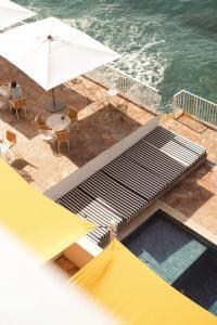 una vista aérea de una piscina con sombrilla y sillas en Les Roches Rouges, a Beaumier hotel, en Saint-Raphaël