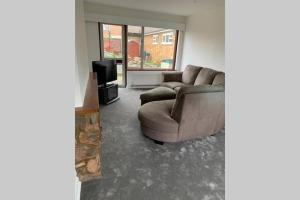 a living room with a couch and a television at 5 Bedroom House with outdoor space in Upminster +11 photos