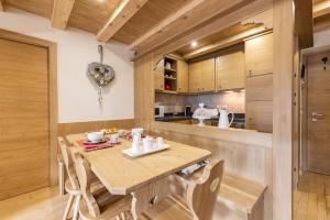 a kitchen with a wooden table and chairs at Casa Ladinia in San Vito di Cadore