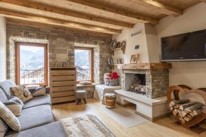 a living room with a fireplace and a tv at Casa Ladinia in San Vito di Cadore