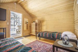 a log cabin bedroom with a bed and a window at Yksityinen järvenrantakohde ryhmille sauna, luonto ja oma rauha in Jämsä
