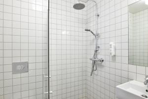 a bathroom with a shower and a sink at Fosshotel Stykkisholmur in Stykkishólmur