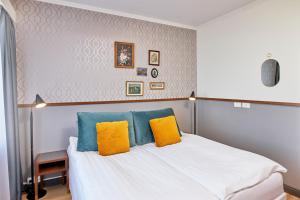 a bedroom with a bed with blue and yellow pillows at Fosshotel Stykkisholmur in Stykkishólmur