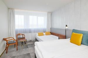 a hotel room with two beds and a chair at Fosshotel Stykkisholmur in Stykkishólmur