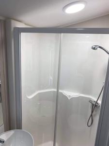 a shower with a glass door in a bathroom at Kellys Holiday Homes 24 Willerby 2 bedrooms caravan in Weeley