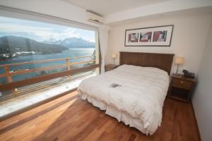 a bedroom with a large window with a view of the water at Hotel Amancay in San Carlos de Bariloche