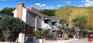 a white building on the side of a street at Hotel Sebari in Villa Carlos Paz