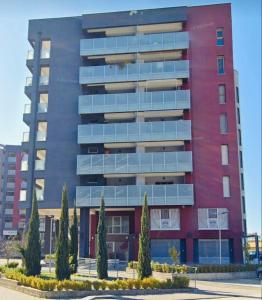 um alto edifício vermelho com árvores em frente em ALMA Casa Vacanze Cosenza em Cosenza