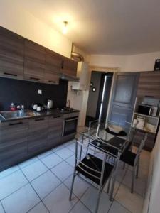 - une cuisine avec une table, une cuisinière et un évier dans l'établissement STAY IN MULHOUSE, à Mulhouse