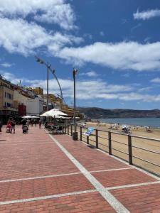 eine Promenade mit einem Strand mit Leuten darauf in der Unterkunft Enjoy Las Canteras in Las Palmas de Gran Canaria