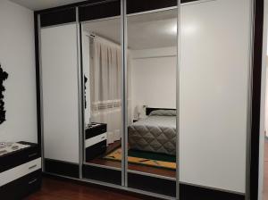 ein Schlafzimmer mit einem verspiegelten Schrank und einem Bett darin in der Unterkunft Piso cangas in Cangas