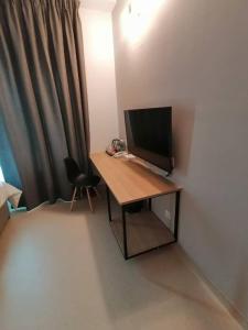 a desk with a television and a chair in a room at Serapi Verdure Hotel in Kuching