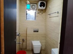 a small bathroom with a toilet and a window at Hotel Sunaina International in Gaya
