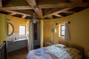 a bedroom with a bed and a bathroom with a sink at La ferme du coustal in Vialot