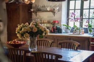 a vase of flowers on a table in a kitchen at La ferme du coustal in Vialot