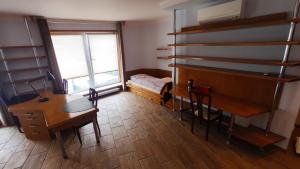 a room with a desk and a bedroom with a bed at Studio 4 in Warsaw