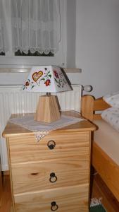 a wooden dresser with a lamp on top of it at Warmińskie Mieszkanko in Biskupiec