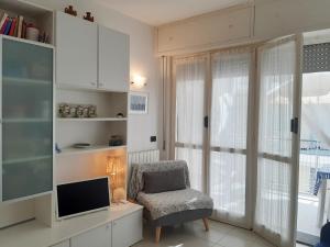 uma sala de estar com uma secretária, uma cadeira e uma televisão em La terrazza tra il Mare e gli Ulivi by Holiday World em Lavagna