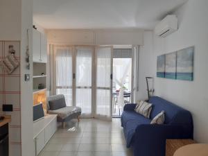 uma sala de estar com um sofá azul e uma cadeira em La terrazza tra il Mare e gli Ulivi by Holiday World em Lavagna