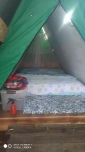 a small bed in a green tent at Recanto da Filó Serra do Cipó in Serra do Cipo