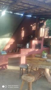 塞拉多席波的住宿－Recanto da Filó Serra do Cipó，配有木桌、桌子和凳子的房间