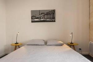 ボルドーにあるAppartement De Lermeのベッドルーム1室(白いベッド1台、テーブル2台付)