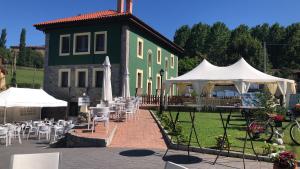 a green building with tables and white umbrellas at Villa Palatina in Bolgues