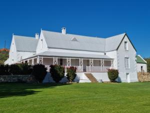 a large white house with a large yard at Red Mountain Ridge Karoo Oasis and Guest Farm in Buffelskloof