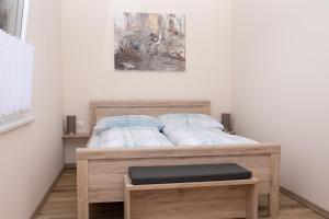 a bedroom with a bed with a wooden frame at Rebenhof Schwalm in Herrnbaumgarten
