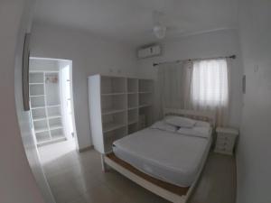 Habitación pequeña con cama y ventana en Vila Weiss Flats, en Ubatuba