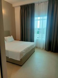 a bedroom with a bed and a large window at Serapi Verdure Hotel in Kuching