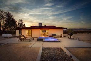 a house with a patio with a fire pit at @ Marbella Lane - The Moon Designer Home right behind the JTNP in Joshua Tree