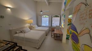 a room with two beds and a couch and a table at Hotel Boutique Casa Rosalía in Valledupar