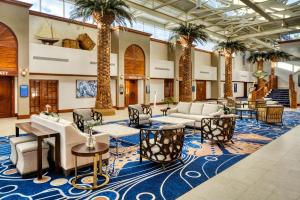 a lobby with palm trees and couches and tables at Island Grand at TradeWinds in St. Pete Beach