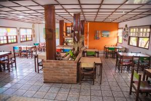 a restaurant with tables and chairs in a room at Pousada das Gaivotas in Guaibim