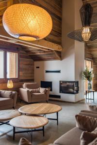 een lobby met banken en tafels en een open haard bij CAPRICORNE - Chalet sur les pistes avec sauna et home cinema in La Toussuire