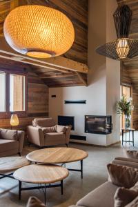 a lobby with couches and tables and a fireplace at CAPRICORNE - Chalet sur les pistes avec sauna et home cinema in La Toussuire