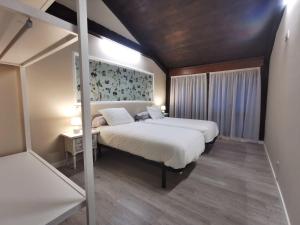 a bedroom with two beds and a painting on the wall at Apartamentos rurales Casa Gorrión - Mazaricos in Sanfoga