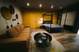 uma sala de estar com um sofá e uma cama em Kostjukowski brand-new apart-hotel em Lviv