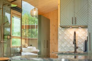a kitchen with a sink and a glass wall at Balthasar Volcano Apartments - Adults only in St. Wolfgang