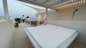 a white bench on a balcony with a table and chairs at Casa Stella in Favignana