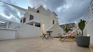 un patio con sedie e un edificio bianco di Casa Stella a Favignana