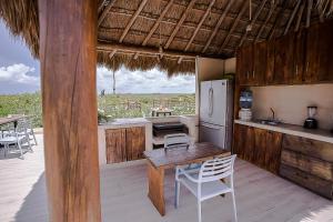 eine Küche mit einem Tisch und einem Kühlschrank auf einer Terrasse in der Unterkunft Sunset House in Tulum