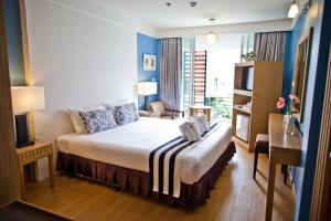 ウドーンターニーにあるパラダイス ホテル ウドンタニのベッドとデスクが備わるホテルルームです。