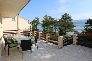 a patio with a table and chairs and a view of the water at Apartment Slavica in Šilo